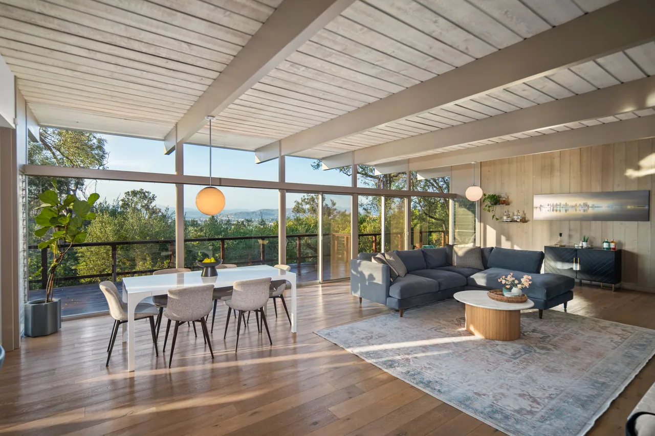 Dining and living areas under the post-and-beam ceiling with valley views