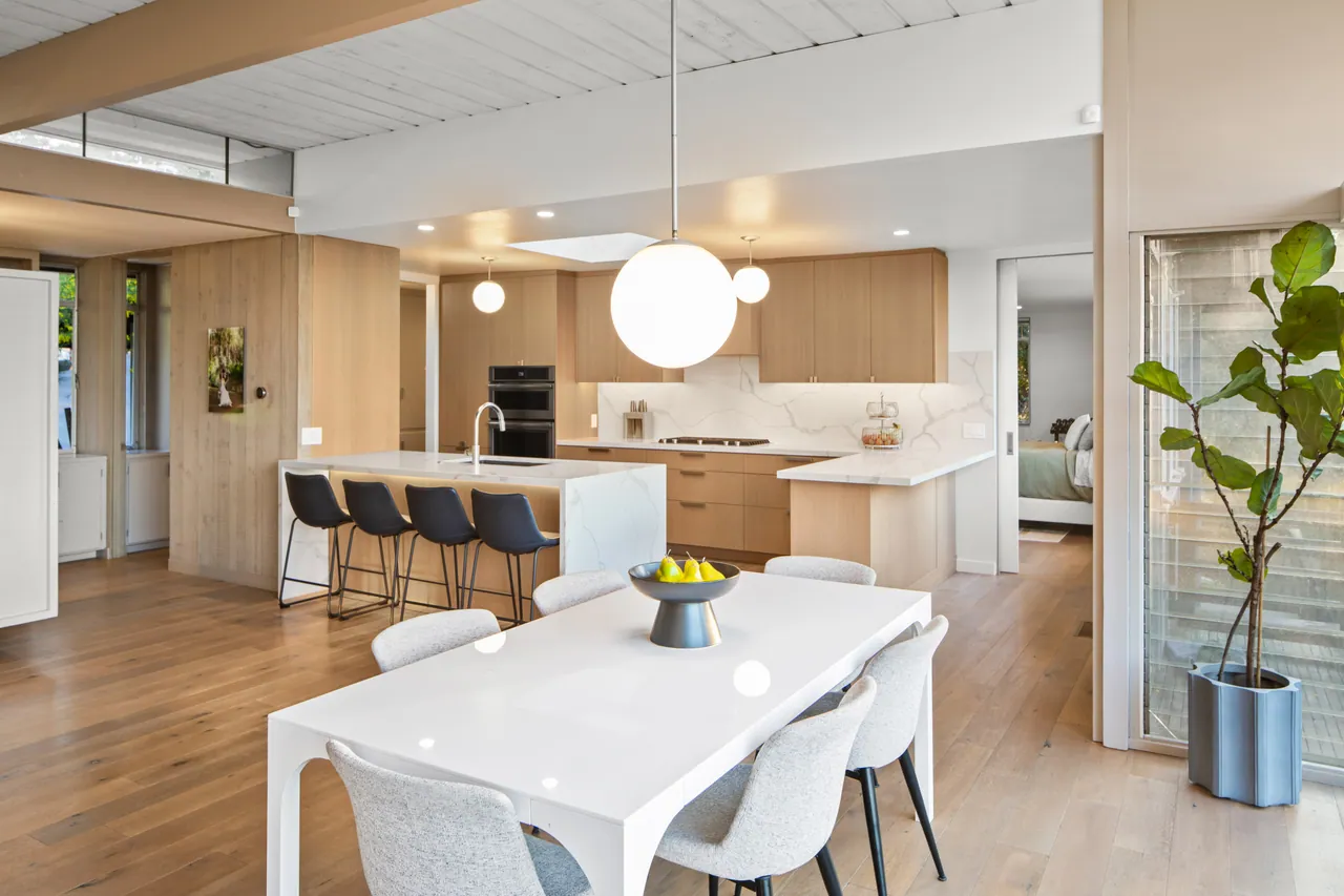 Kitchen and dining area with oak cabinetry and a globe pendant