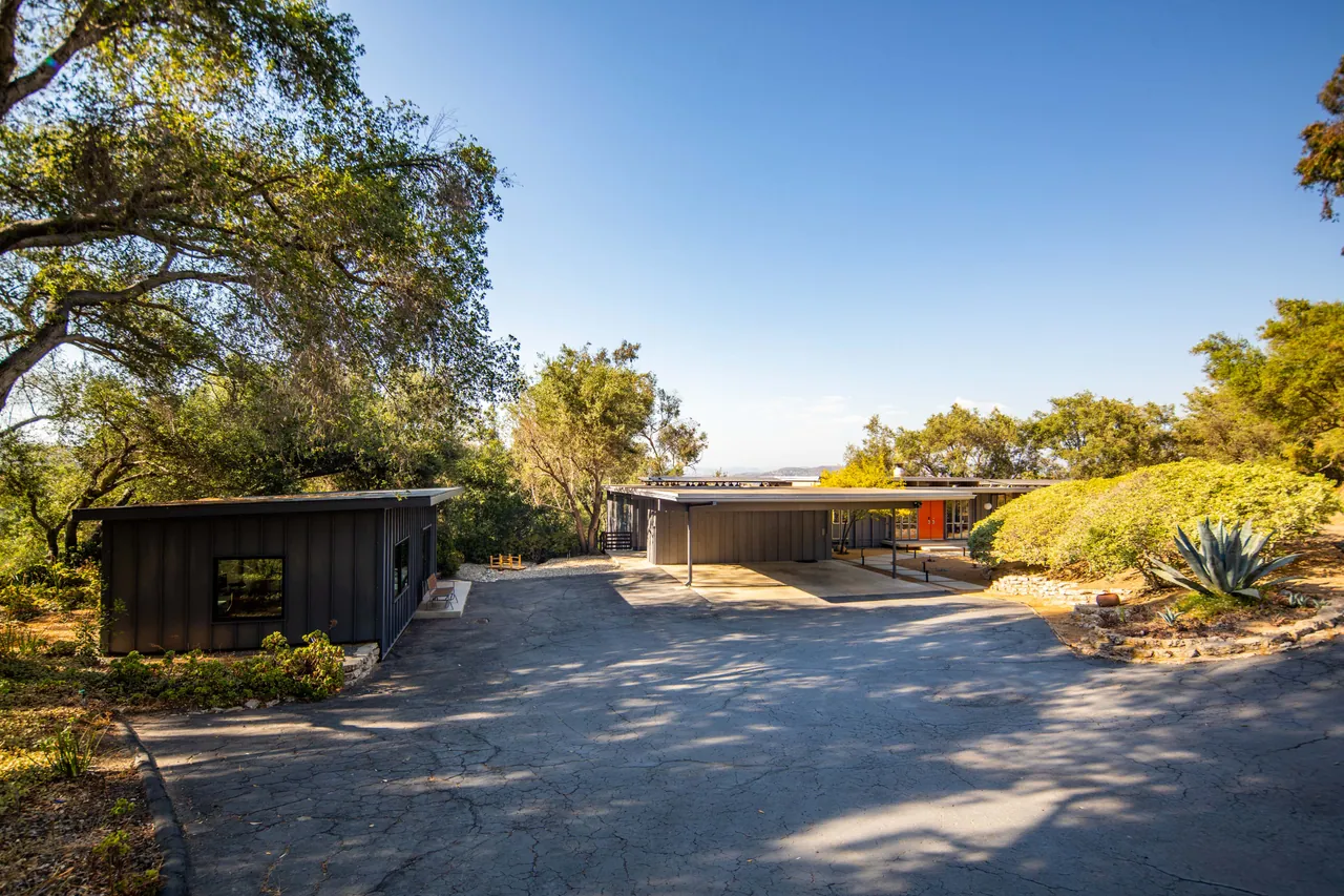 The private drive arriving at the carport and office addition, framed by oaks