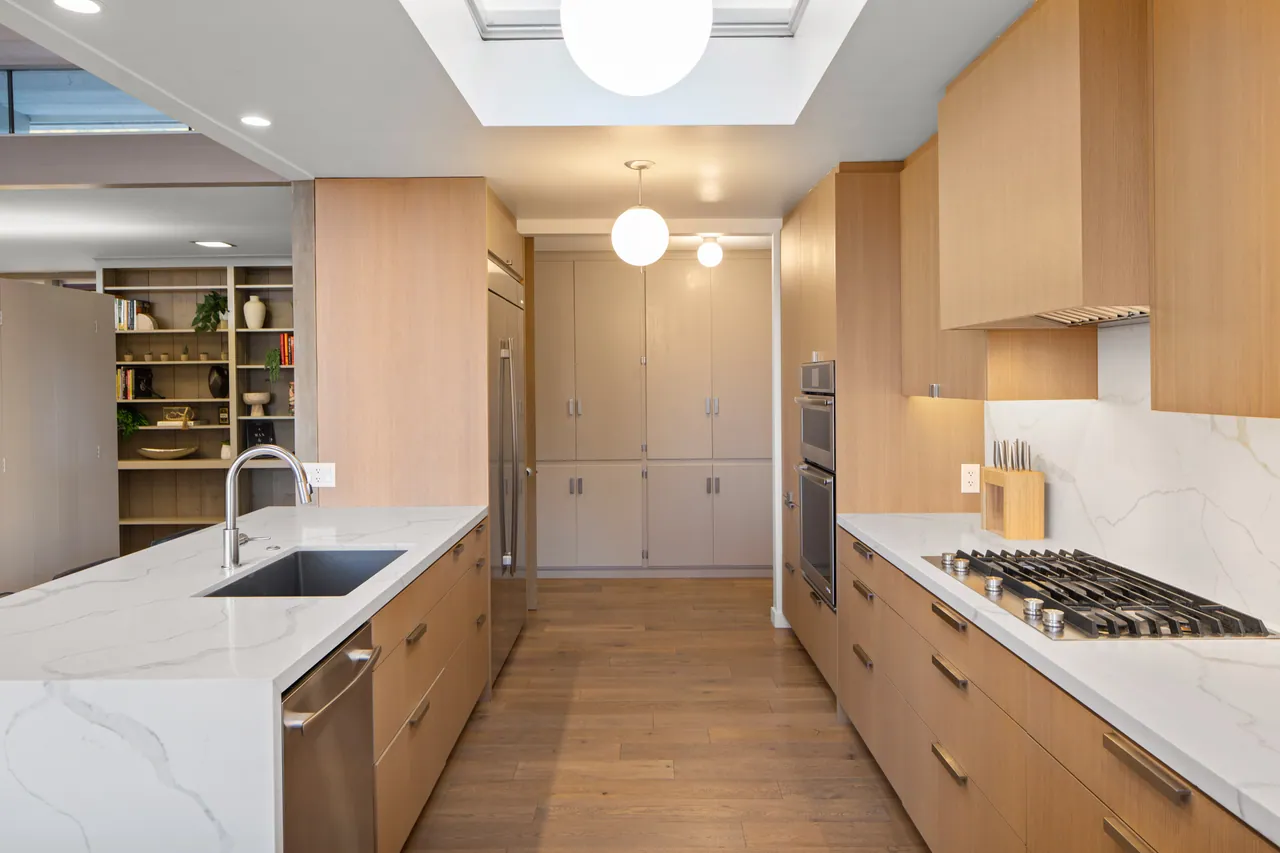 Kitchen with gas cooktop, oak cabinetry and skylight