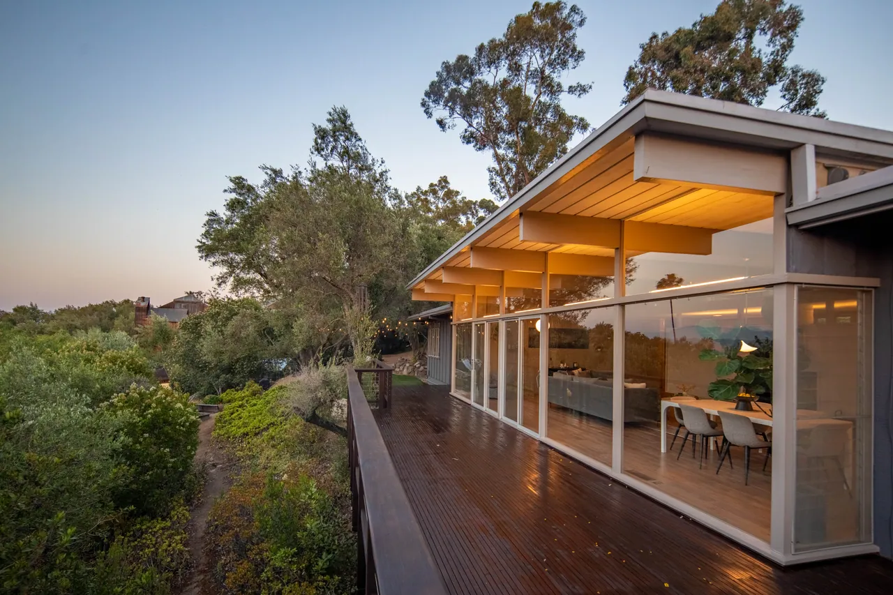 The deck at dusk running the length of the glass wall