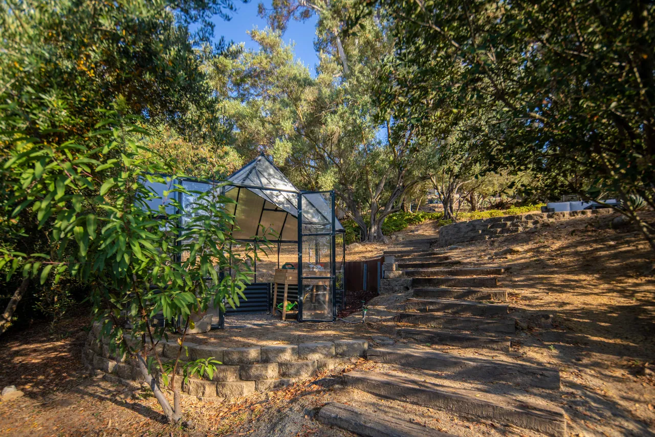 Greenhouse on the hillside with stone steps